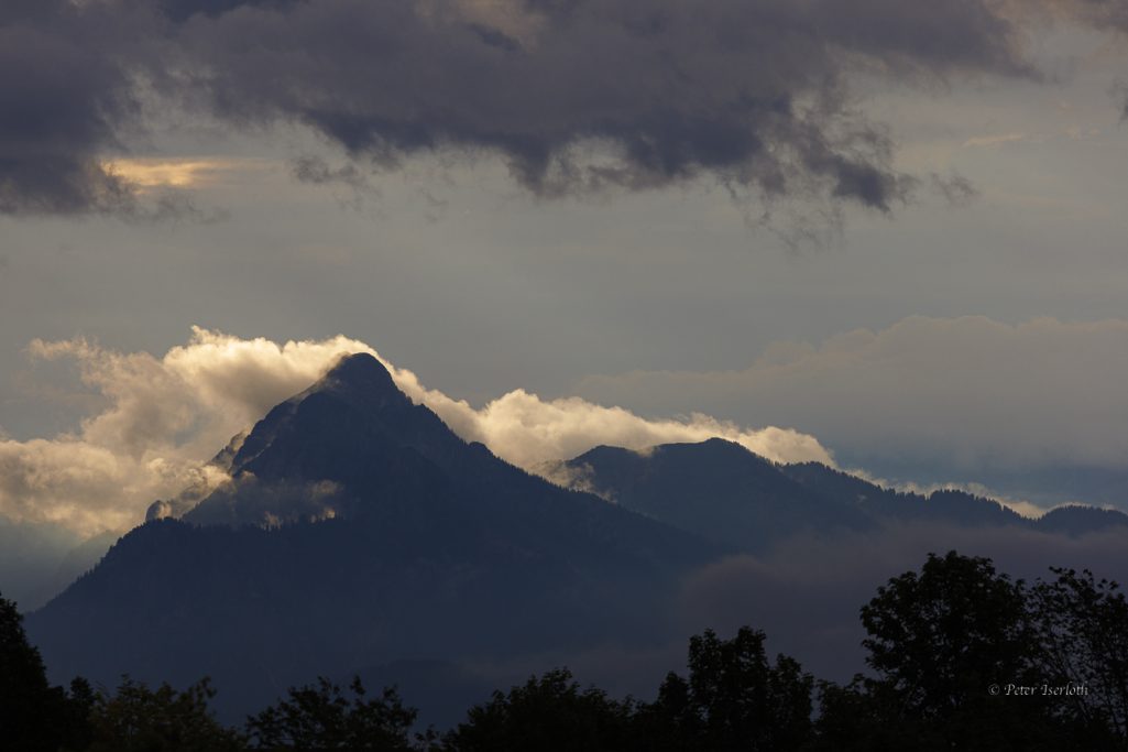 Fotografie vom Bergmassiv Säuling, mit aufsteigende Nebelschwaden.