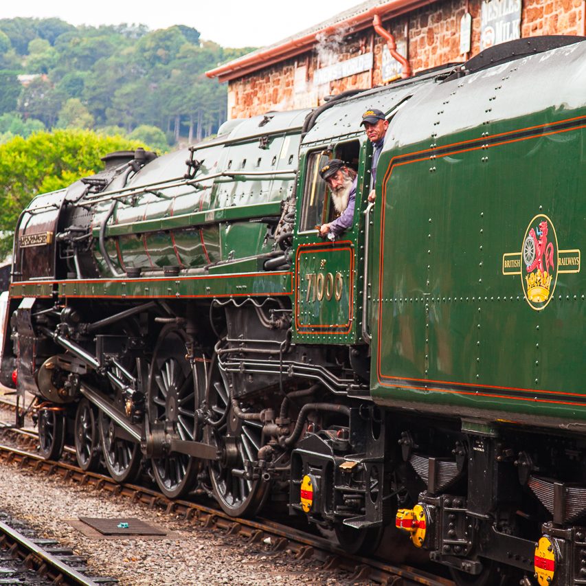 West Somerset Railway "Duke of Gloucester". Dampflok mit grüner Lackierung, Fahrer schaut aus dem Fenster. Historische Eisenbahn.