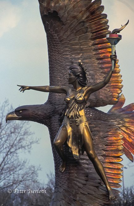 Bronzestatue vor dem ehemaligen Flughafen Hamburg - Fuhlsbüttel. Skulptur einer weiblichen Figur, die eine Fackel hält, mit einem Adler im Hintergrund.